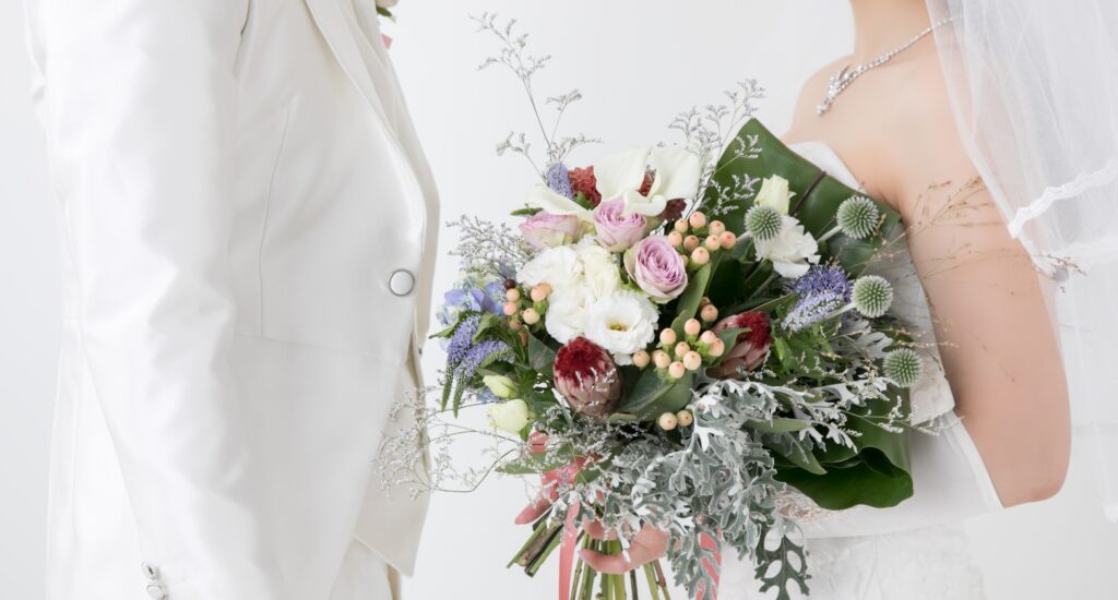 タキシードの男性とウェディングドレスでブーケをもった女性