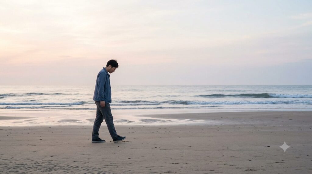 砂浜で貝殻を探す男性
