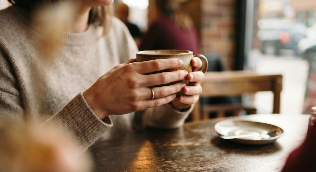 カフェで相手の話を聞きながらカップを持つ手元